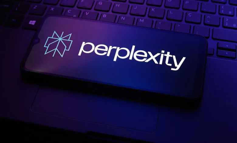 Smartphone displays Perplexity AI logo on laptop keyboard, dark blue lighting.