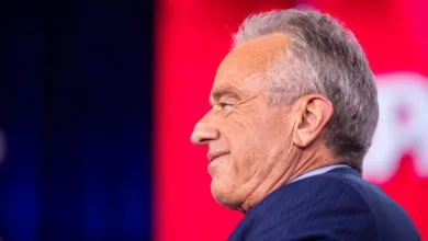 Profile of Robert F. Kennedy Jr. against a red and blue backdrop.