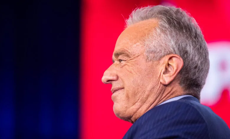 Profile of Robert F. Kennedy Jr. against a red and blue backdrop.