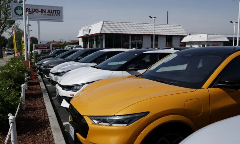 Electric vehicles lined up at Plug-In Auto Supercenter dealership.