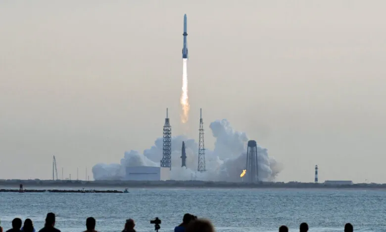 Rocket launches from Cape Canaveral, plume of smoke and fire visible.