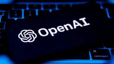 OpenAI logo and text on a dark card resting on a laptop keyboard.