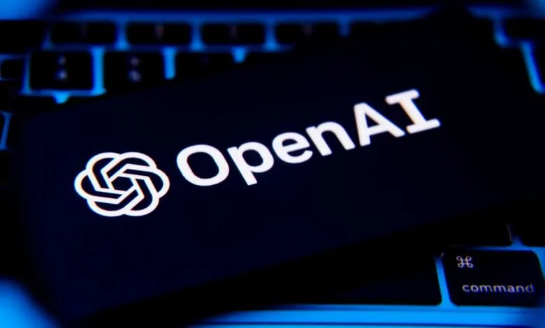 OpenAI logo and text on a dark card resting on a laptop keyboard.