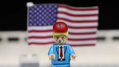 Lego figure with MAGA hat in front of American flag.
