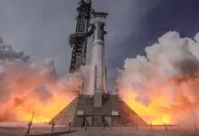 Rocket launching with intense flames and smoke against a cloudy sky.