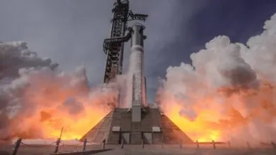 Rocket launching with intense flames and smoke against a cloudy sky.