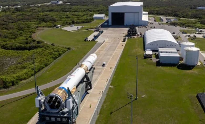 Blue Origin rocket on transporter moving towards launch facility.