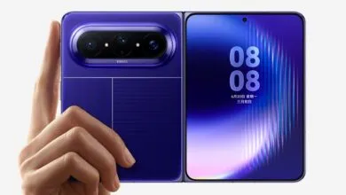 Foldable purple smartphone with advanced camera system being held by a hand.