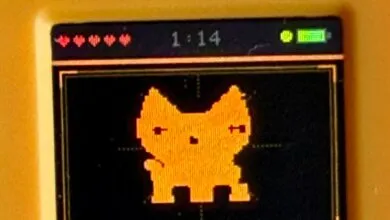 Handheld game console screen showing pixelated cat character with full battery.