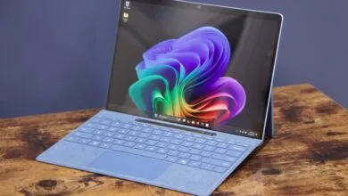 Microsoft Surface Pro on a wooden desk, displaying a colorful floral wallpaper.