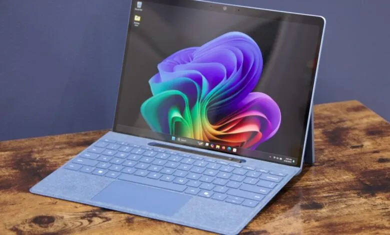 Microsoft Surface Pro on a wooden desk, displaying a colorful floral wallpaper.
