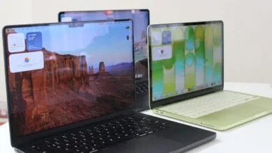 Three Apple MacBooks on a white surface, each with a different screen display.