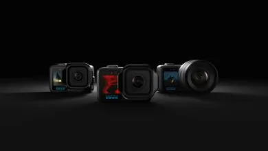 Five GoPro cameras with screens displaying various scenes, arranged on a dark surface.