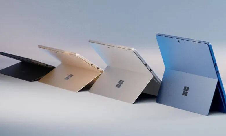 Four Microsoft Surface Pro tablets in black, gold, silver, and blue.