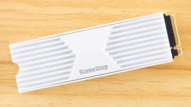GameStop branded NVMe SSD with white heatsink on wood surface.