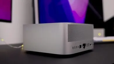 Silver Mac Studio desktop computer on a dark surface.