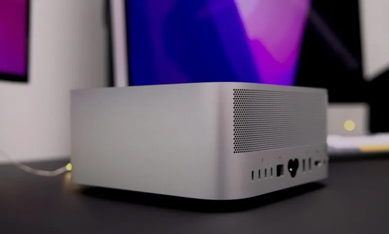 Silver Mac Studio desktop computer on a dark surface.