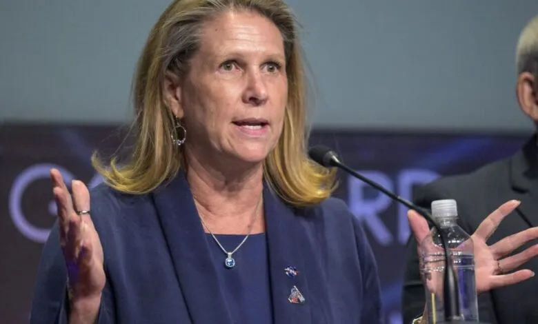 Pam Melroy speaks at a podium with a microphone, gesturing with her hands.