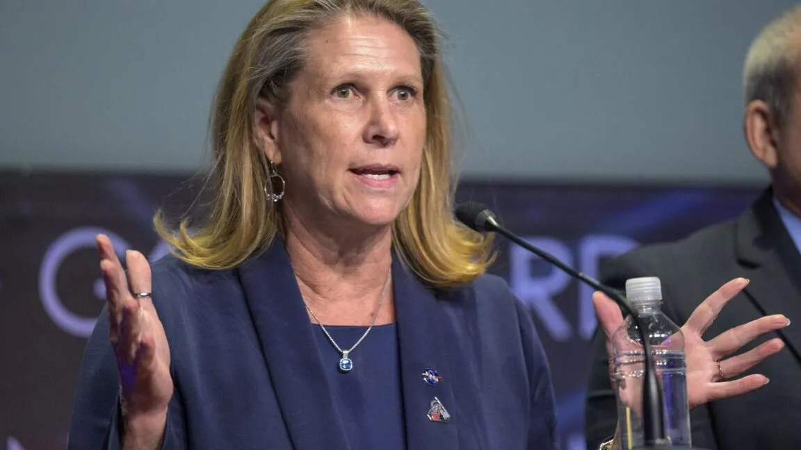 Pam Melroy speaks at a podium with a microphone, gesturing with her hands.