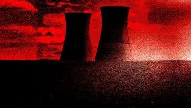 Two cooling towers silhouetted against a red sky, ominous mood.