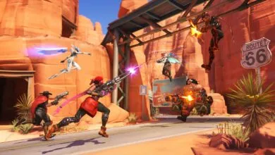 Overwatch 2 characters in a desert battle scene with Route 66 sign.