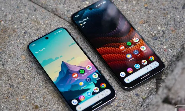 Two smartphones displaying home screens with app icons on a textured gray surface.