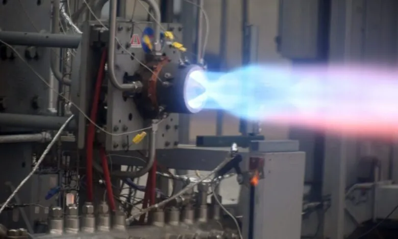 Rocket engine firing with blue and red exhaust plume.