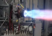 Rocket engine firing with blue and red exhaust plume.