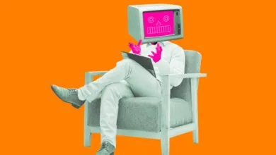 Person with TV head sits in chair, holding a tablet, on orange background.