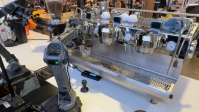 Robotic arm making espresso with a professional machine.
