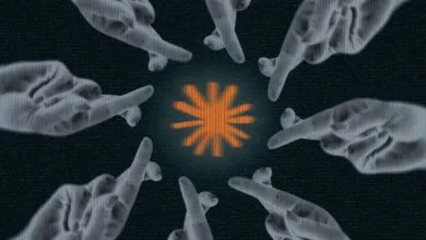 Fingers crossed around a glowing orange starburst on a dark background.