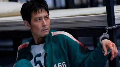 Lee Jung-jae as Seong Gi-hun in Squid Game, looking distressed with blood and handcuffs.