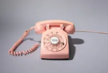Vintage pink rotary phone with 'Version History' on the dial.