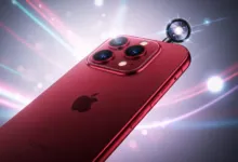 Close-up of a red iPhone with triple camera system and lens attachment.