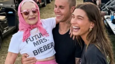 Woman in 'Future Mrs. Bieber' shirt held by Justin and Hailey Bieber, all smiling.