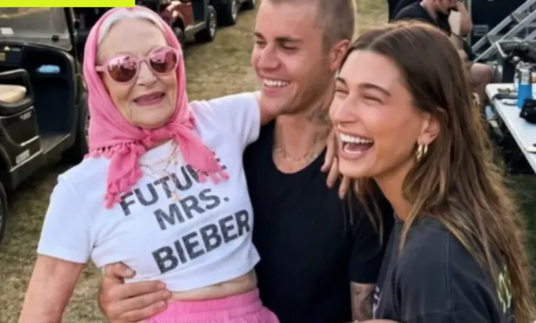 Woman in 'Future Mrs. Bieber' shirt held by Justin and Hailey Bieber, all smiling.