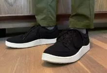 Person wearing black Allbirds Pacer sneakers with white soles.