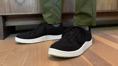 Person wearing black Allbirds Pacer sneakers with white soles.