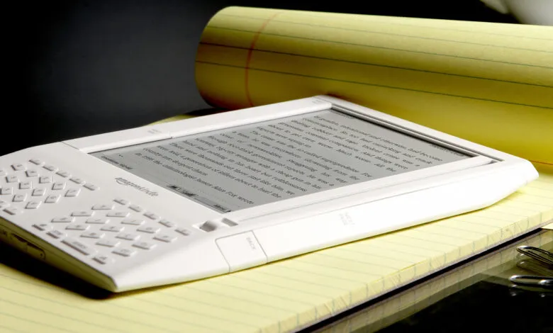 Amazon Kindle e-reader on yellow legal pad, displaying text.