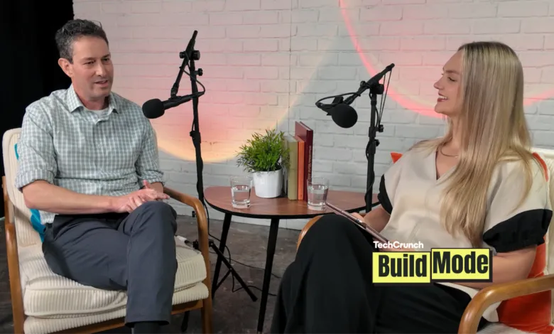 Two people recording a podcast in a studio setting, smiling and engaged.