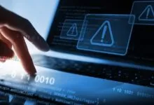 Finger on laptop touchpad with code and warning signs, cyber security concept.