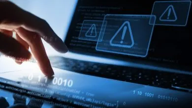 Finger on laptop touchpad with code and warning signs, cyber security concept.