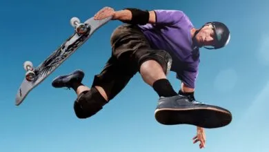 Skateboarder in mid-air performing trick against a clear blue sky.