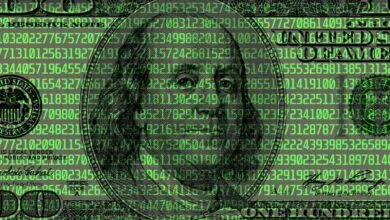 One hundred dollar bill overlaid with green digital code.
