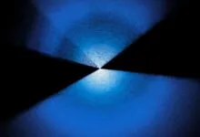 Abstract blue and black geometric pattern with a central light source.