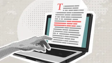 Hand interacting with laptop screen showing text document.