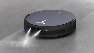 Robot vacuum cleaner spraying cleaning solution on a gray floor.