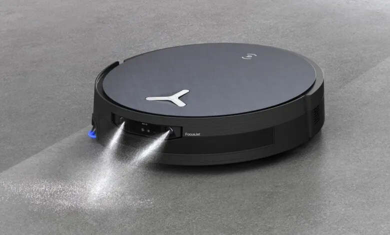 Robot vacuum cleaner spraying cleaning solution on a gray floor.
