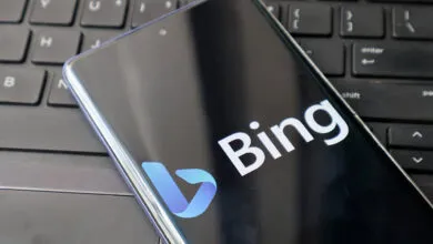 Smartphone displaying the Bing logo resting on a black computer keyboard.