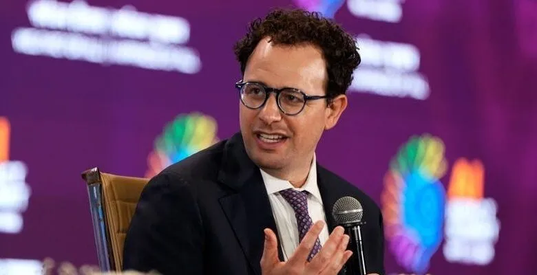 Nathaniel Gleicher speaks at event, wearing glasses and suit.